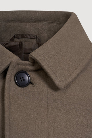 Close-up of a brown coat with a button on a white background